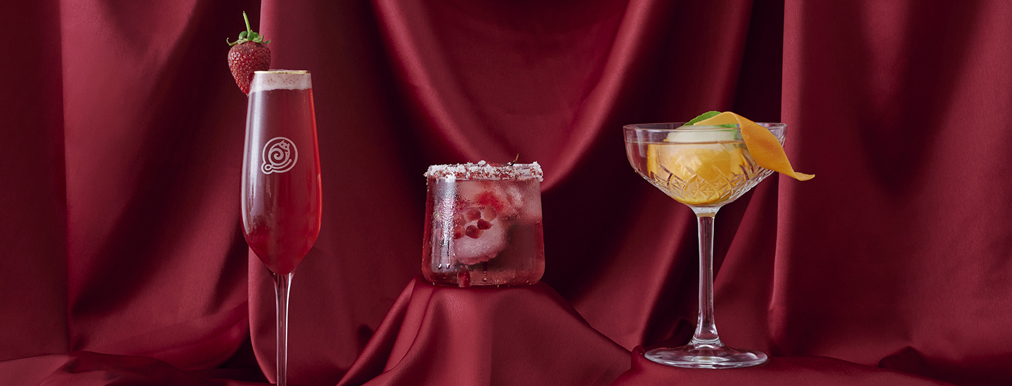 three elegant cocktails on a burgundy satin background, boujee, bougie, brutal fruit, the suite, the suite edit, drinks, entertainment, three cocktails, cocktails satin backdrop, cocktail recipes, entertaining